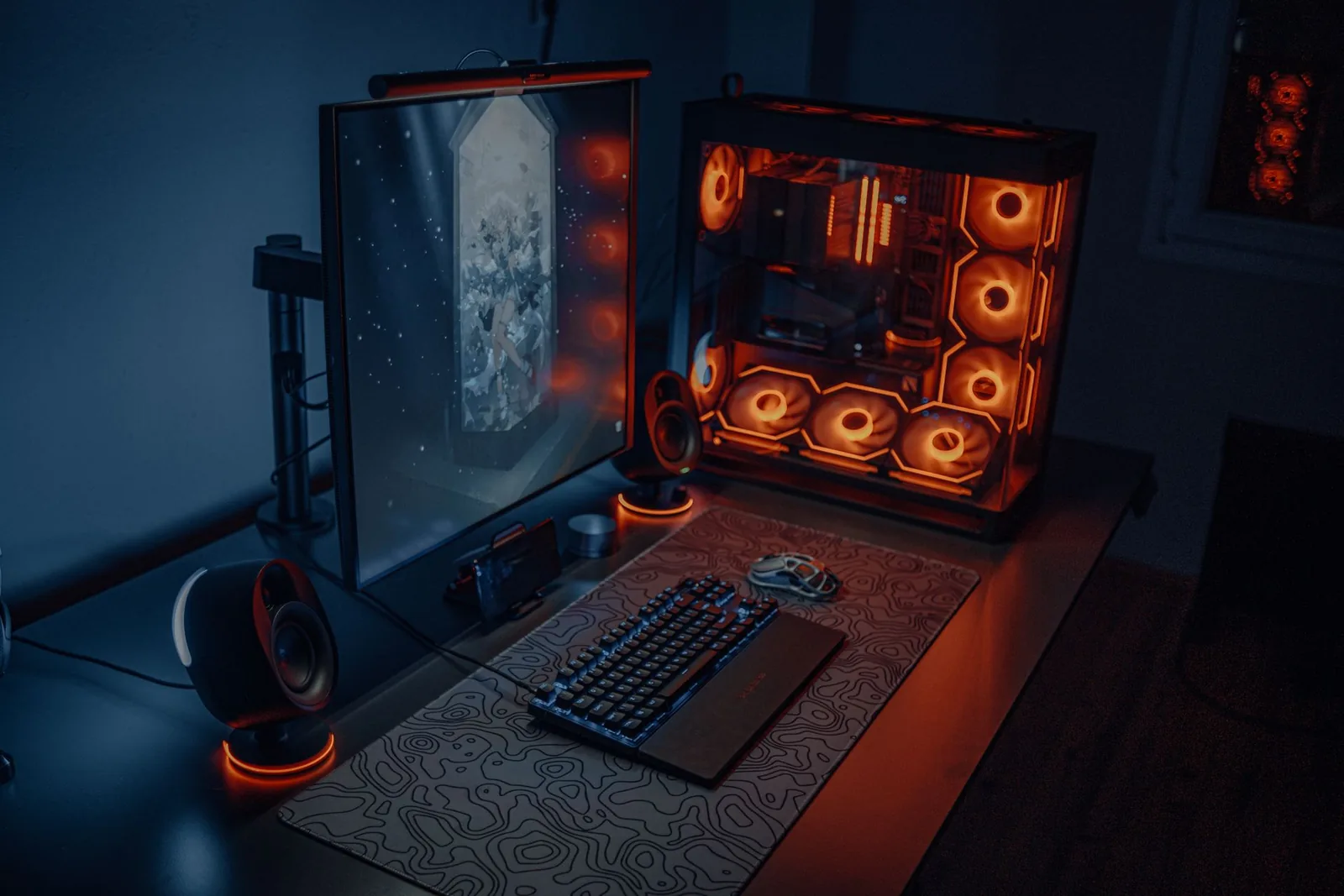 Pelitietokone RGB-valoin, näyttö ja näppäimistö hämärässä huoneessa