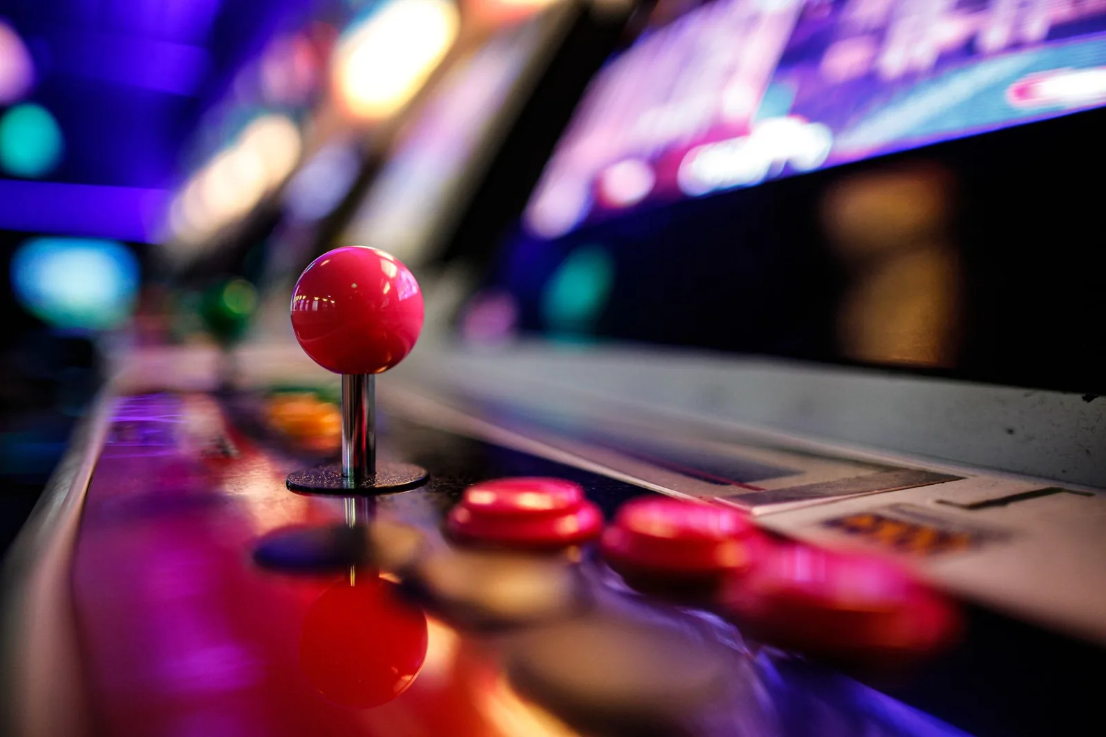 Arcade-pelin punainen ohjainsauva ja neonvaloin hehkuvat painikkeet